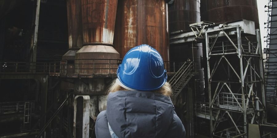 Technicien de maintenance casqué devant une ligne de production